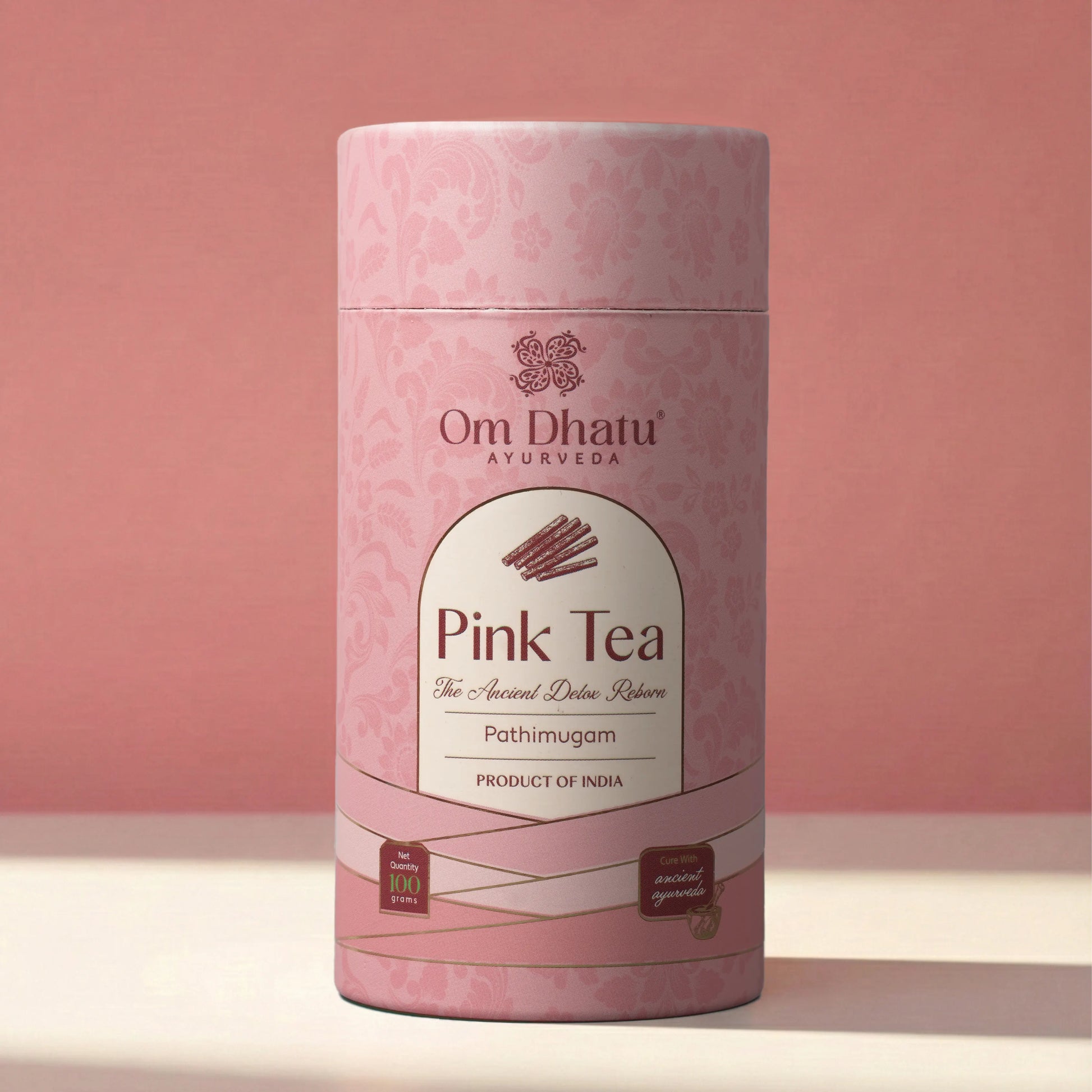 A refined glass of Omdhatu Pink Tea next to the signature can, emphasizing the cooling Ayurvedic properties