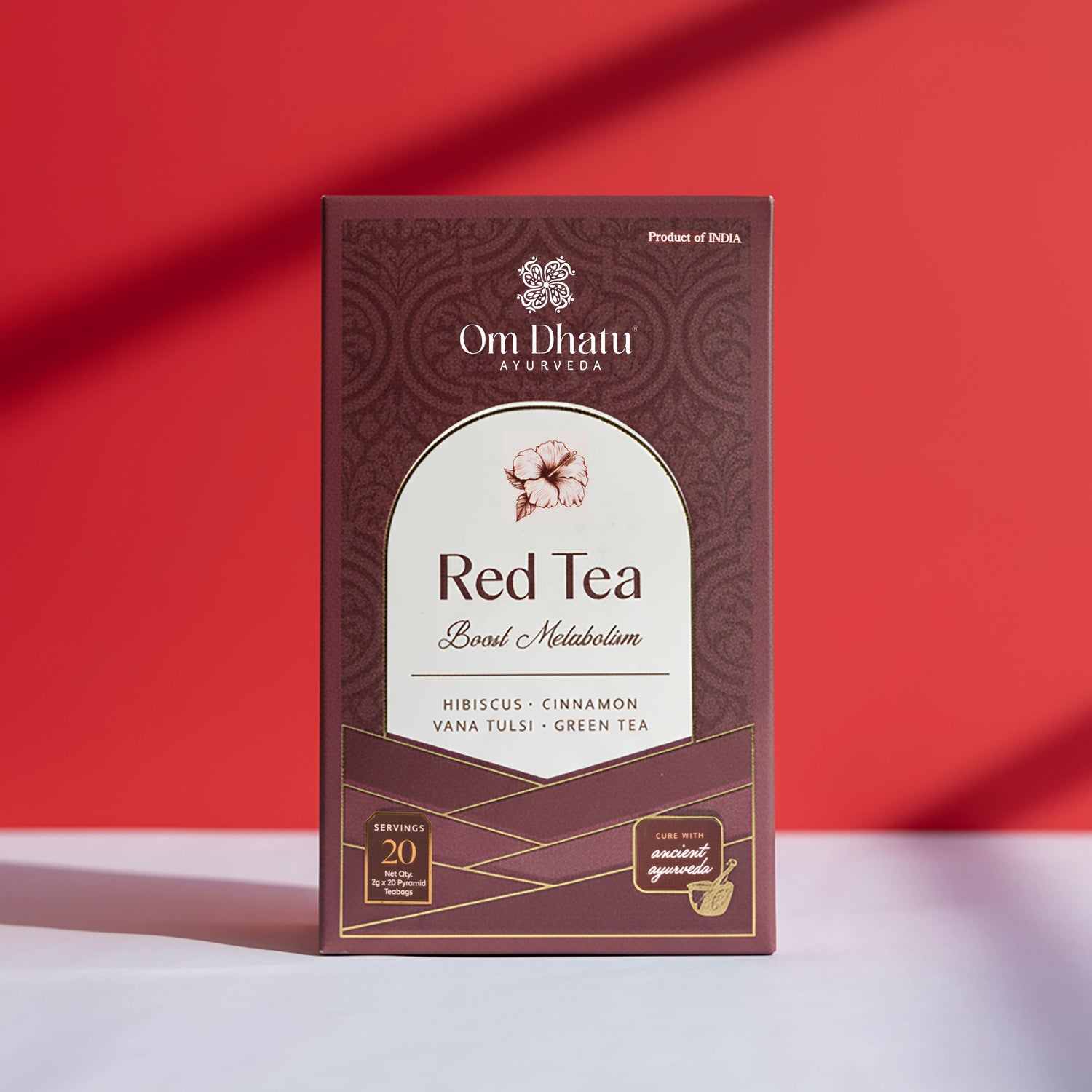 Box of Omdhatu Ayurvedic Red Tea bags featuring vibrant hibiscus flowers and traditional herbal ingredients for Boosting Metabolism.