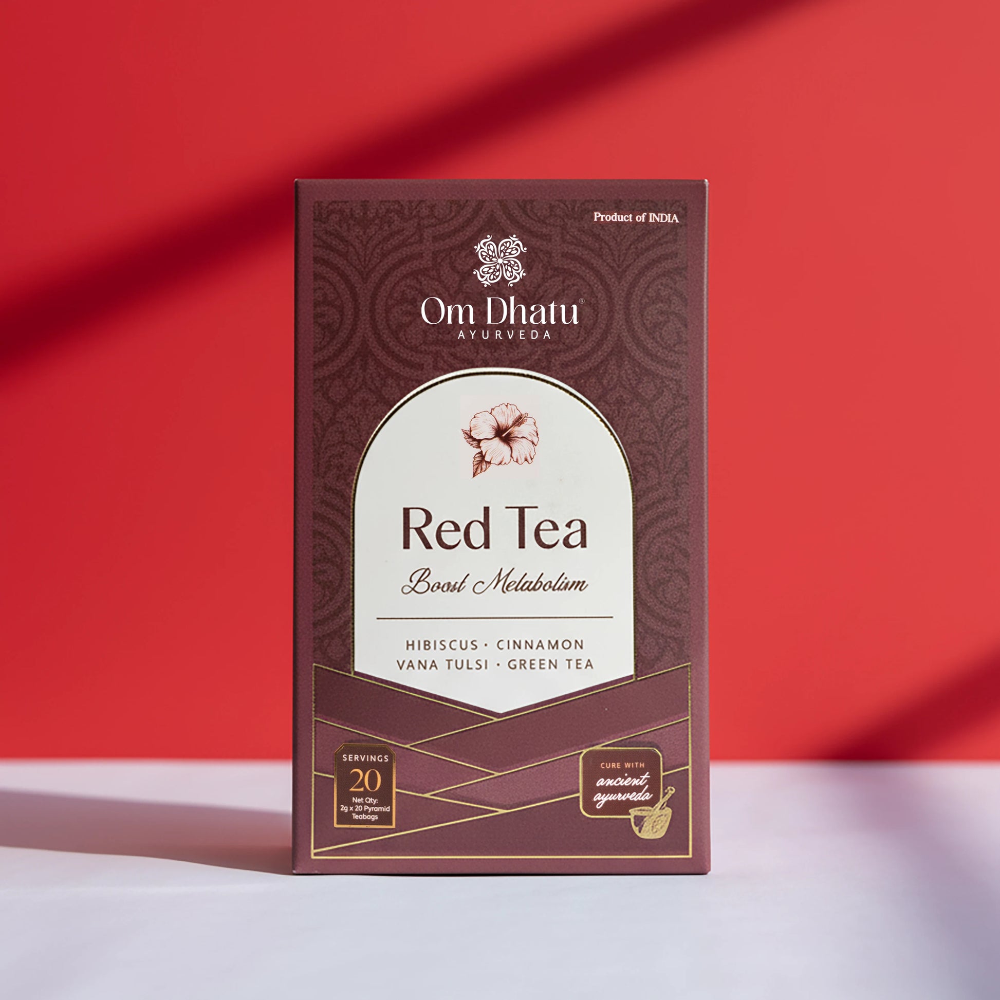 Box of Omdhatu Ayurvedic Red Tea bags featuring vibrant hibiscus flowers and traditional herbal ingredients for Boosting Metabolism.