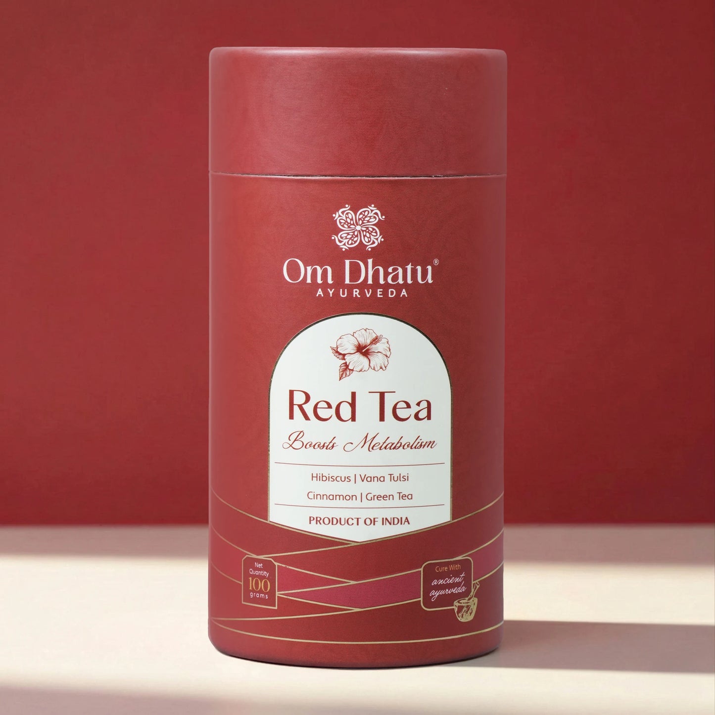 Close-up of Omdhatu Red Tea loose-leaf tea blend showing dried hibiscus petals, tulsi, and cinnamon shards inside the open can