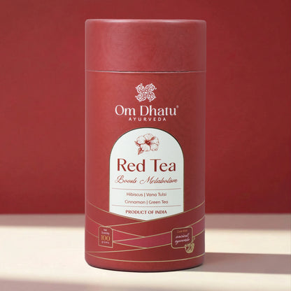 Close-up of Omdhatu Red Tea loose-leaf tea blend showing dried hibiscus petals, tulsi, and cinnamon shards inside the open can